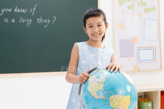 Ritratto di ragazza della scuola con globo — Foto stock