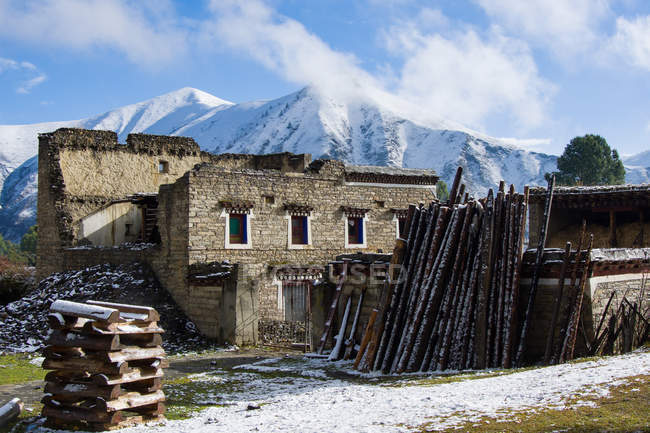 Viejo edificio en hermosas montañas cubiertas de nieve, Tíbet - foto de stock