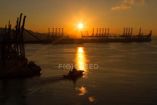 Vista de ángulo alto de equipos industriales y barcos en el puerto al atardecer, Shenzhen, China - foto de stock