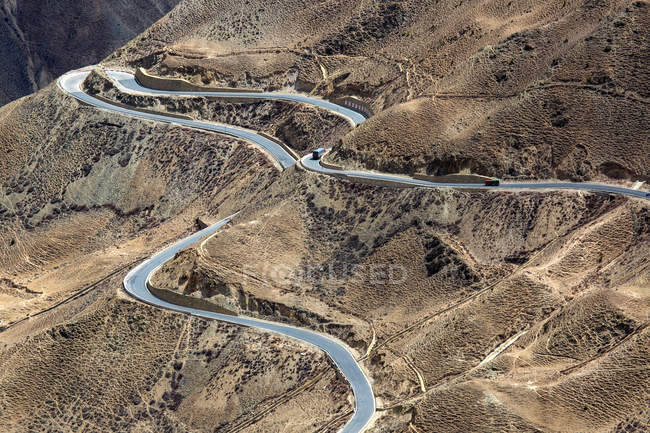 Vista aérea del tráfico en la sinuosa carretera Sichuan-Tibet en las montañas - foto de stock