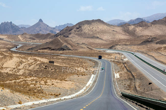 Vista de ángulo alto del tráfico en la autopista Qinghai-Tibet y las montañas durante el día - foto de stock