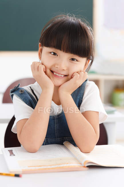 Retrato de uma menina sentada na sala de aula — Fotografia de Stock