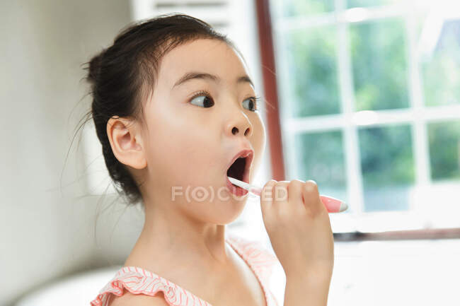 Petite fille brossant les dents — Photo de stock