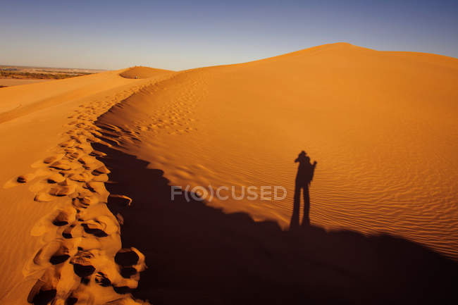 Тінь людини і дивовижні піщані дюни в пустелі Дунхуанг, Ґансу. — стокове фото