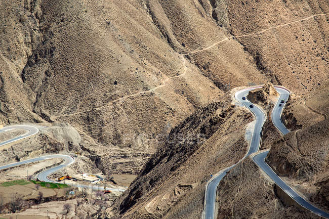 Vista aérea de la sinuosa carretera Sichuan-Tibet con tráfico en las montañas - foto de stock