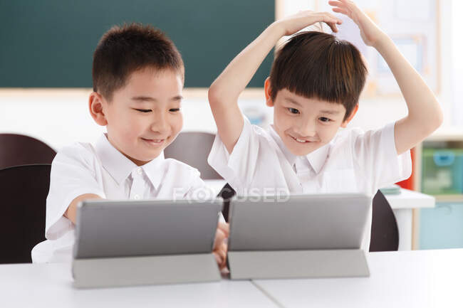 Dos estudiantes usando tableta digital en el aula - foto de stock