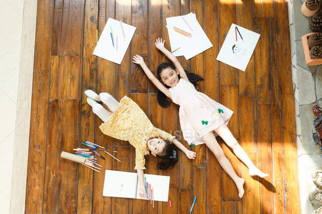 Deux filles couchées sur le sol sur le dos — Photo de stock