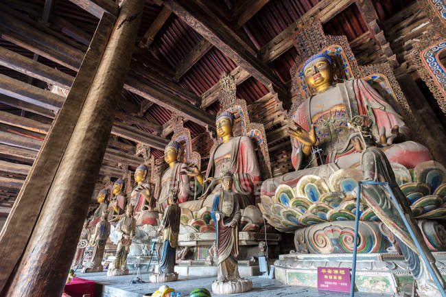 Vista de ángulo bajo de estatuas antiguas en el templo de Dafo, Liaoning, China - foto de stock