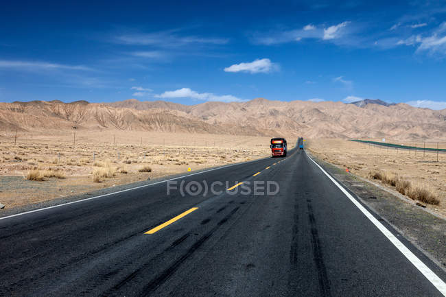 Tráfico en la autopista Qinghai-Tibet y hermosas montañas durante el día - foto de stock