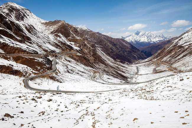 Route venteuse sur la montagne enneigée Jinbalang, Sichuan, Chine — Photo de stock