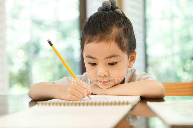 Маленька дівчинка вчиться вдома — стокове фото