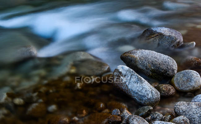 Close-up view of stones in blurred rapid water at Tibet — Stock Photo