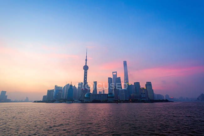 Architecture urbaine avec bâtiments modernes et gratte-ciel au coucher du soleil, Shanghai — Photo de stock