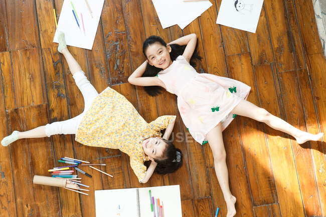 Due ragazze sdraiate sul pavimento sul retro — Foto stock