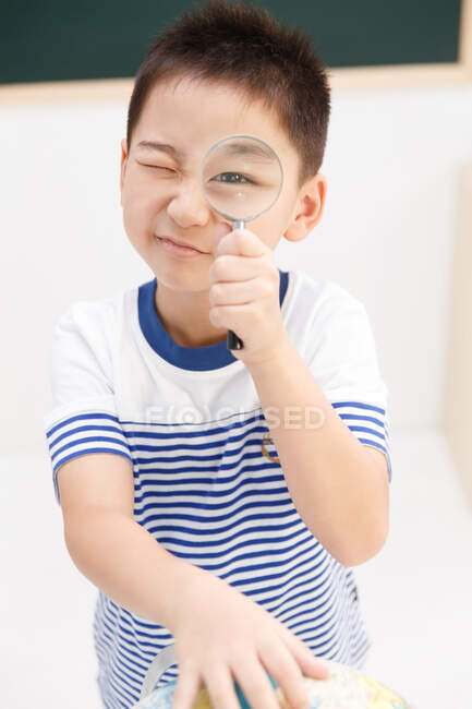 School boy using magnifying Glass — Stock Photo