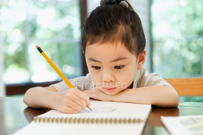 Дівчинка вчиться вдома. — стокове фото