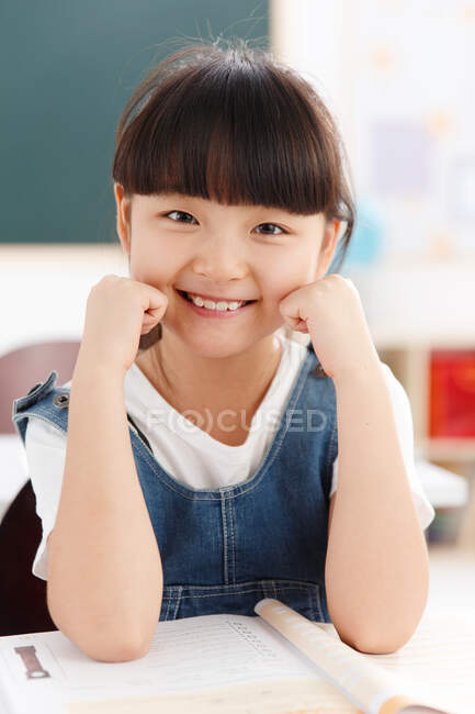 Portrait d'une fille assise en classe — Photo de stock