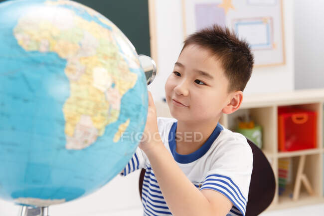 Menino da escola com globo — Fotografia de Stock