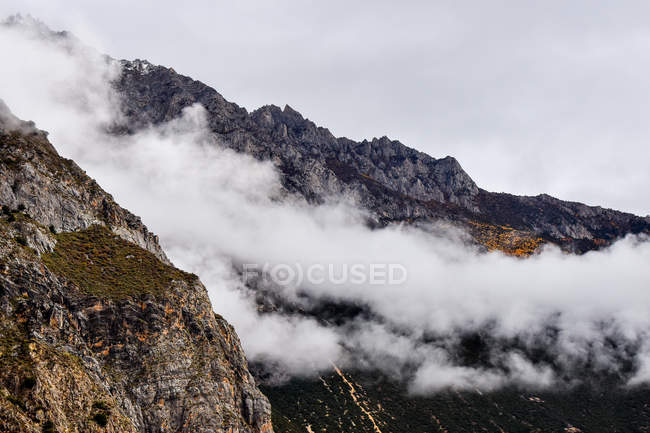 Bela paisagem com montanhas rochosas em nuvens, Tibete — Fotografia de Stock