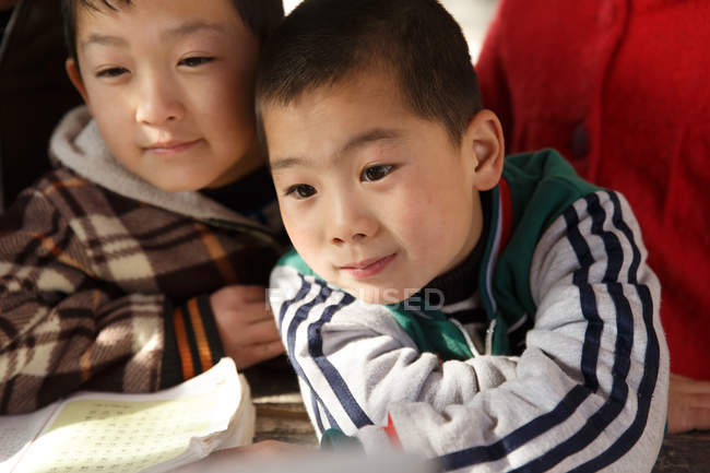 Vista de cerca de los estudiantes chinos de primaria que estudian en la escuela rural - foto de stock