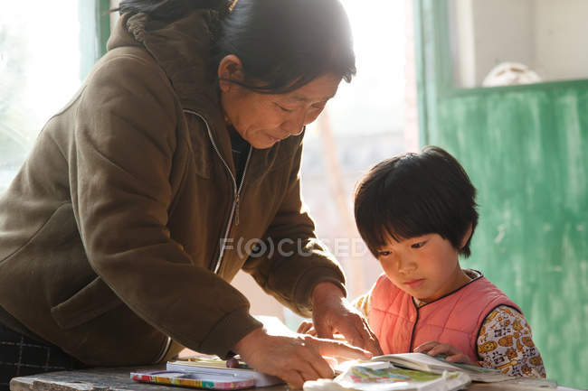 Rural chinese female teacher and pupil in the classroom — Stock Photo