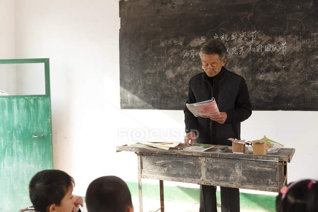 Männliche chinesische Landgrundschullehrerin und Schüler im Klassenzimmer — Stockfoto