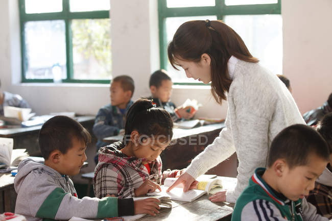 Chinese rural female teacher and pupils in the classroom — Stock Photo