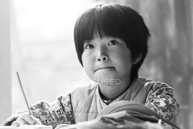 Retrato de estudante chinesa focada estudando na escola primária rural — Fotografia de Stock