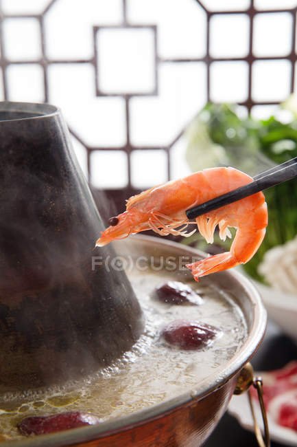 Vista close-up de pauzinhos com camarão e panela quente — Fotografia de Stock