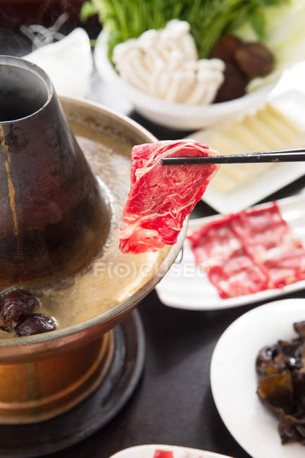 Vista close-up de hotpot de carneiro com ingredientes deliciosos na mesa — Fotografia de Stock