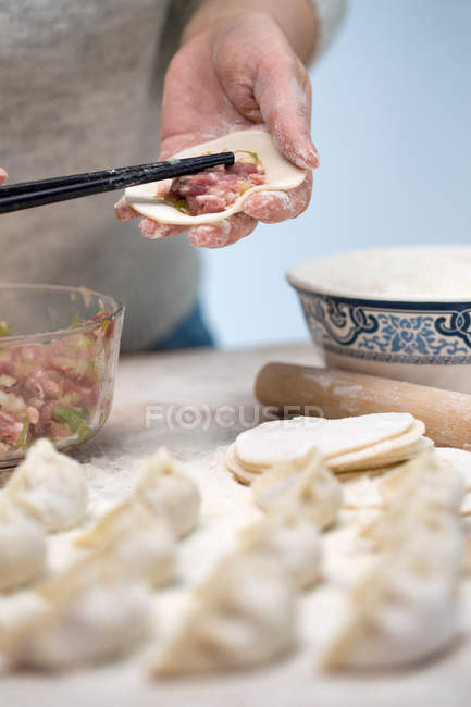 Abgeschnittene Aufnahme einer Frau bei der Zubereitung köstlicher traditioneller chinesischer Knödel — Stockfoto