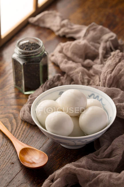 Vista de cerca del tazón con bolas de arroz glutinoso en la mesa de madera - foto de stock