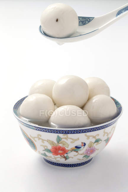 Vue rapprochée de cuillère en porcelaine et bol avec des boules de riz gluantes sur blanc — Photo de stock