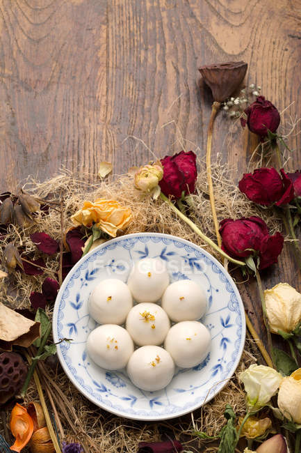 Vista dall'alto delle palline di riso glutinoso per il Festival delle Lanterne e fiori secchi sul tavolo di legno — Foto stock