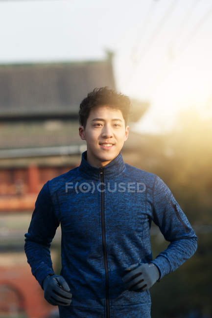 Красивий молодий азіатський чоловік у спортивному одязі біжить на відкритому повітрі вранці — стокове фото