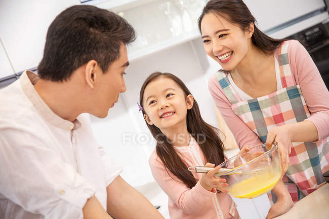 Glückliche asiatische Familie mit einem Kind, das gemeinsam in der Küche kocht — Stockfoto