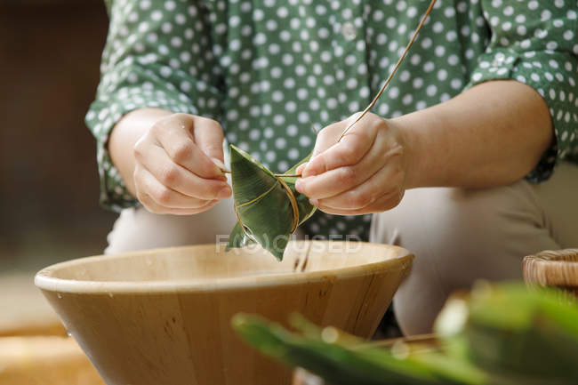 Colpo ritagliato di donna che prepara tradizionale piatto di riso cinese zongzi — Foto stock
