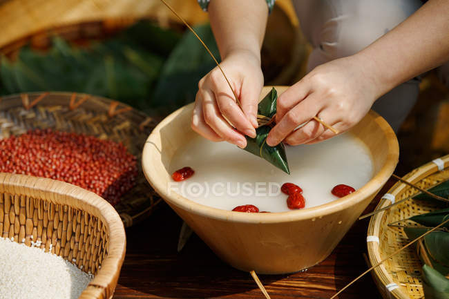 Tiro cortado de mulher cozinhar prato chinês tradicional zongzi — Fotografia de Stock
