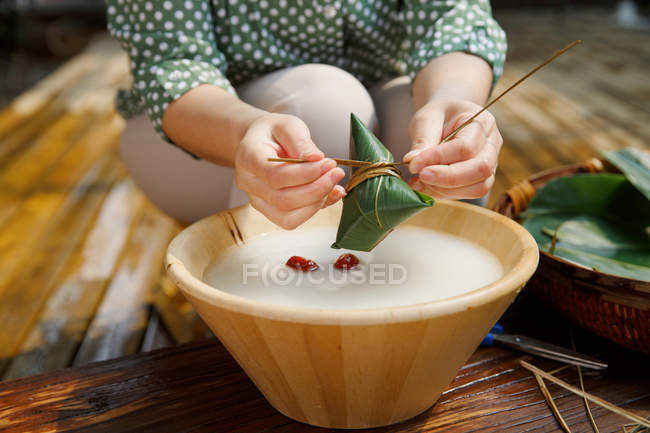 Vue partielle de la femme d'âge moyen faisant zongzi — Photo de stock