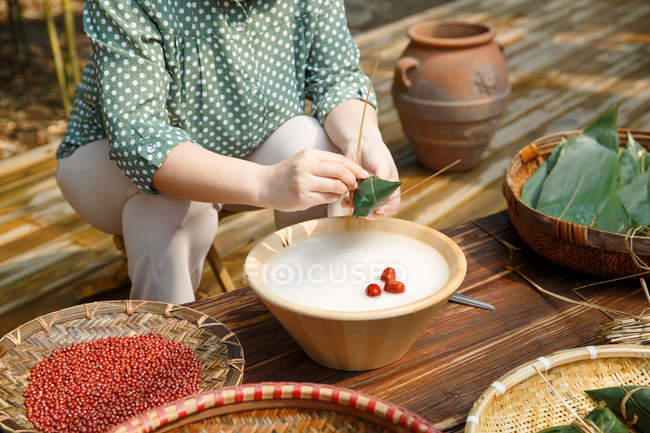 Cropped shot of middle-aged woman making zongzi — Stock Photo
