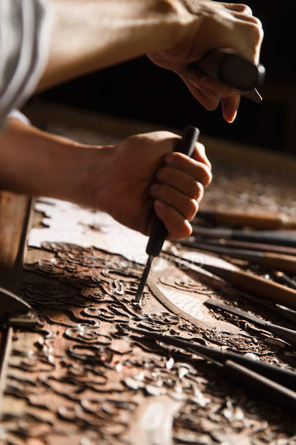 Close-up visão parcial das mãos masculinas durante a gravura de madeira na oficina — Fotografia de Stock