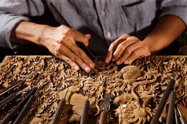 Tiro recortado de mãos masculinas durante a gravura de madeira, arte tradicional chinesa e artesanato — Fotografia de Stock