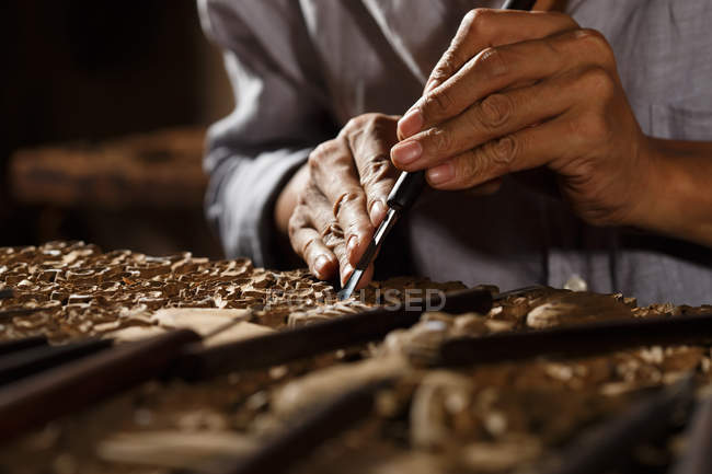 Vista parziale dell'uomo durante la lavorazione del legno incisione in officina — Foto stock