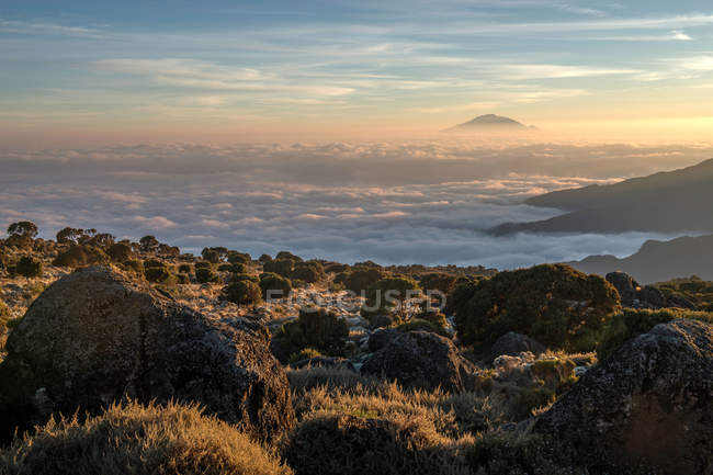 Beautiful sunset in scenic mountains covered with clouds — Stock Photo
