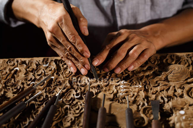 Ritagliato colpo di asiatico uomo durante la lavorazione del legno incisione a officina — Foto stock