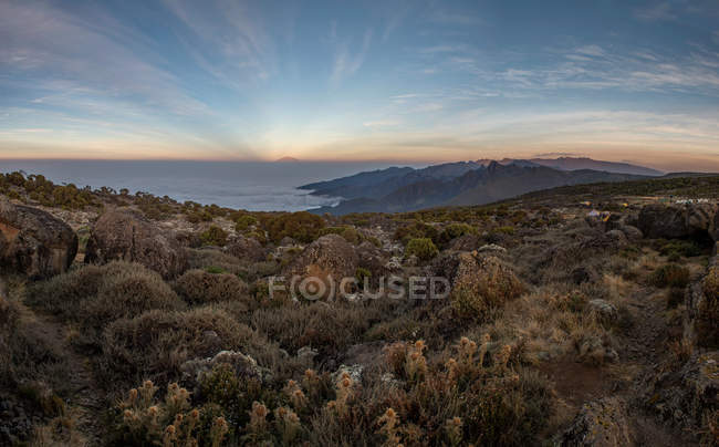 Paesaggio incredibile con montagne rocciose e nuvole al tramonto scenico — Foto stock