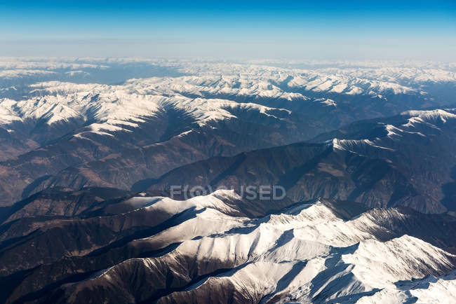 Vue aérienne de belles montagnes enneigées et ciel bleu — Photo de stock