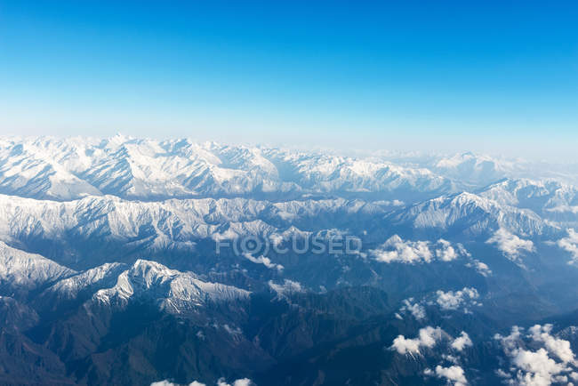 Aerial view of amazing rocky mountains, clouds and blue sky — Stock Photo