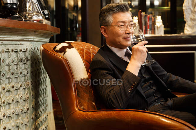 Empresários bem sucedidos estão bebendo vinho tinto — Fotografia de Stock