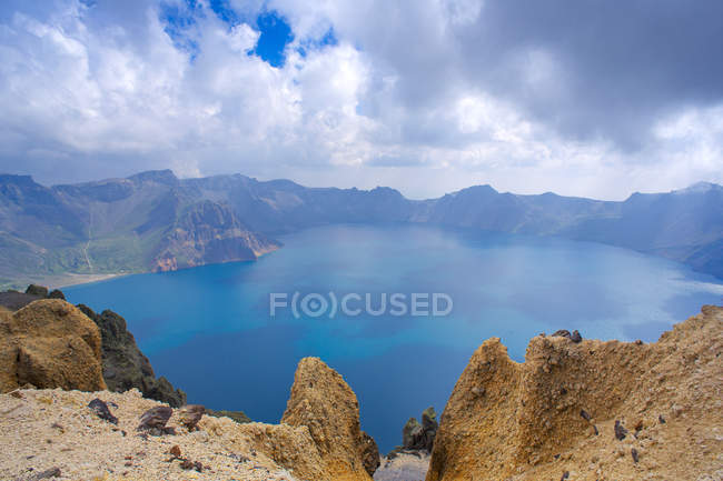 Hermoso paisaje de montaña con cuerpo de agua y cielo azul - foto de stock